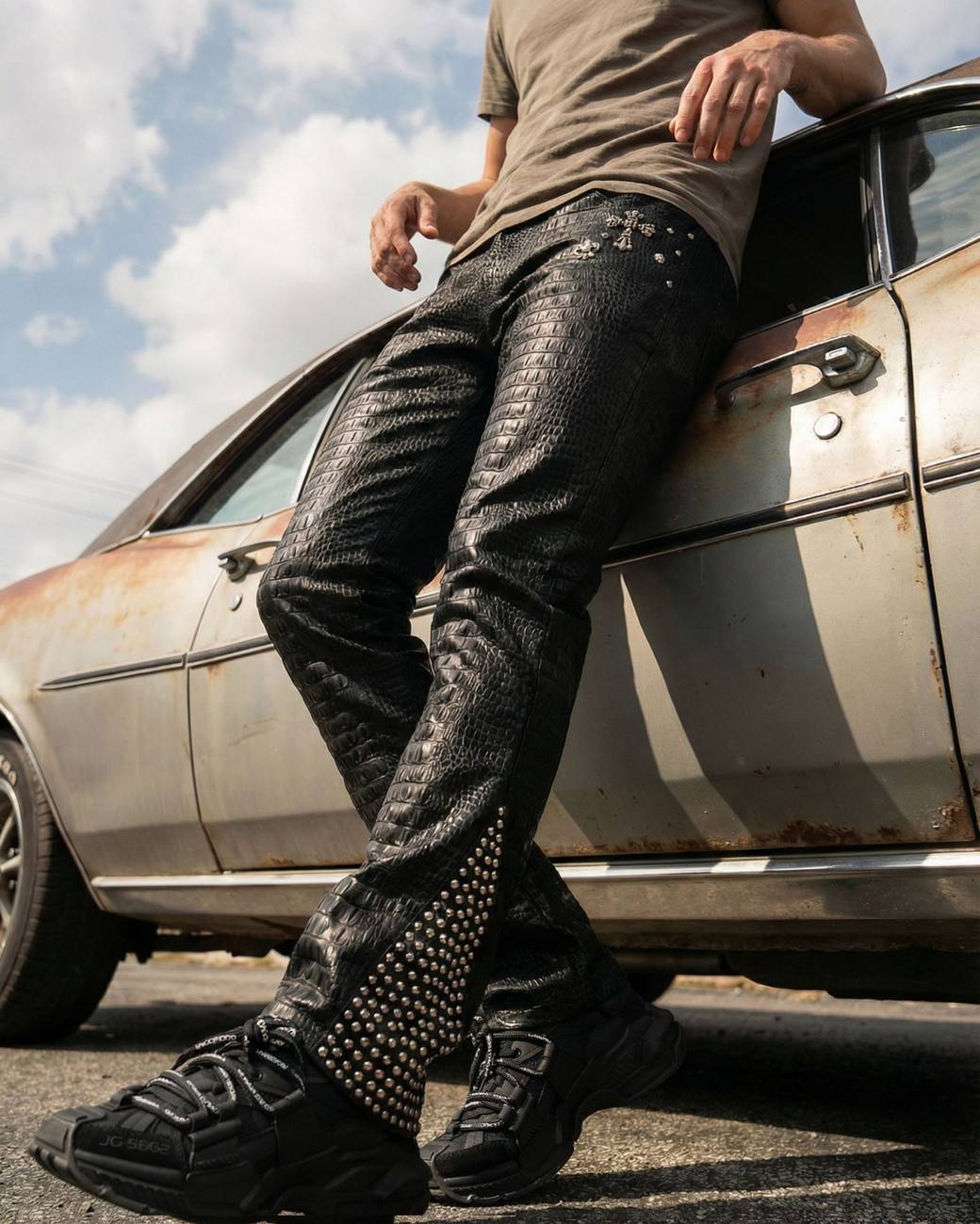 Model in PREME distressed black denim leaning on a rusted car